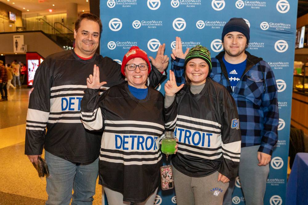 Four alums smiling for a photo.
